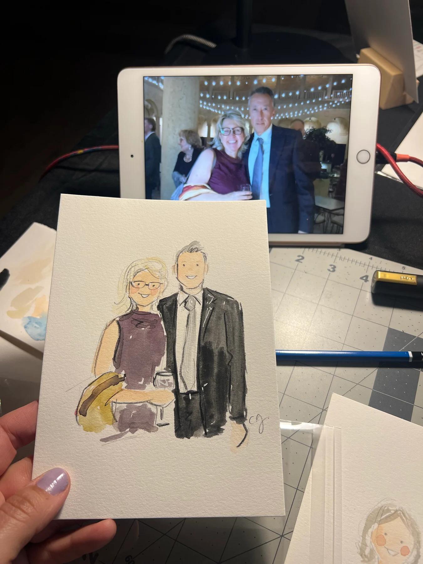 A watercolor portrait of a formally dressed couple with their reference photograph