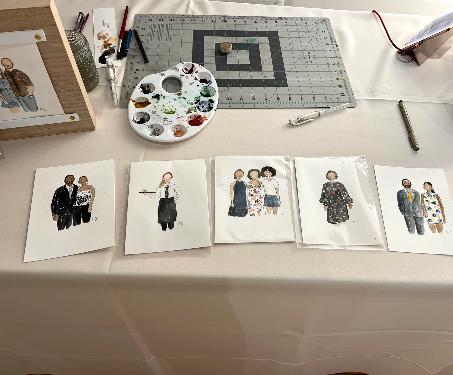 Individual, couple, and group portraits displayed at Carmen’s painting station